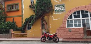 a yellow building with a red motorcycle parked out front