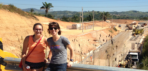 two women standing on a bridge overlooking a construction site