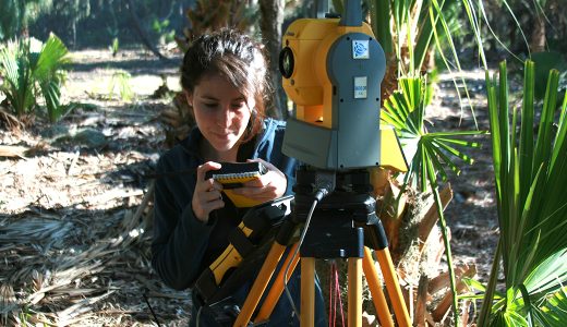 archaeologist using surveying equipment