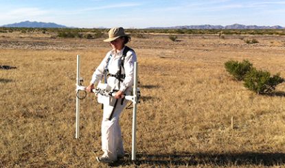 anthropologist in a field with equipment
