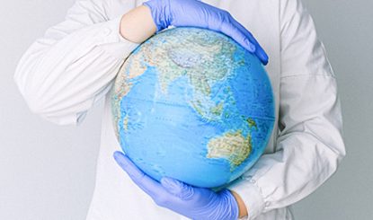 person wearing latex gloves holding globe