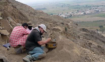 archaeologists at a mountainside dig site